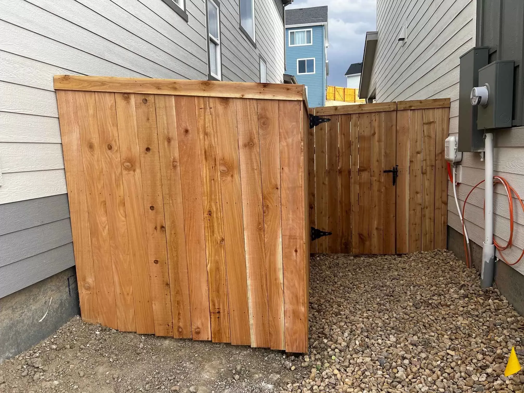 Residential fence installation beside a landscaped yard