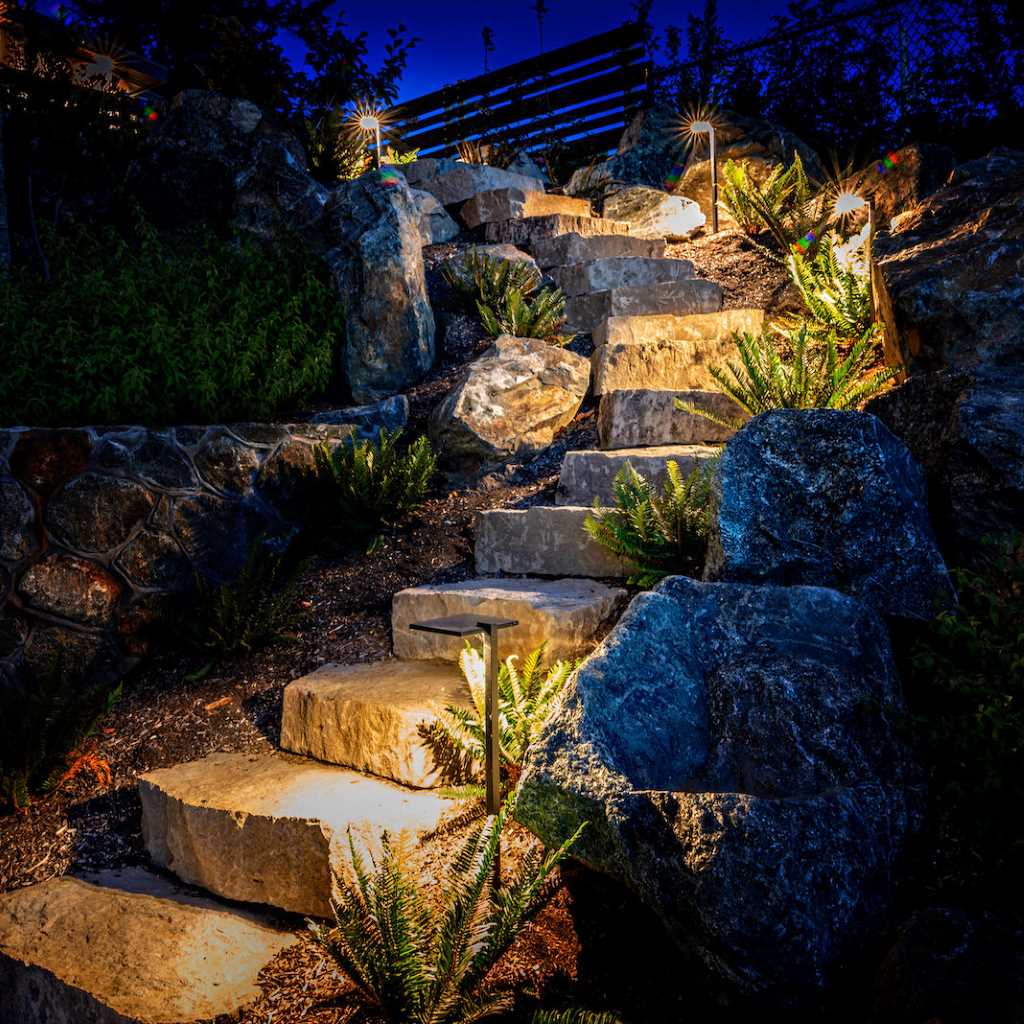 A beautifully illuminated stone staircase at night, showcasing expertly installed outdoor lighting in Parker, CO.