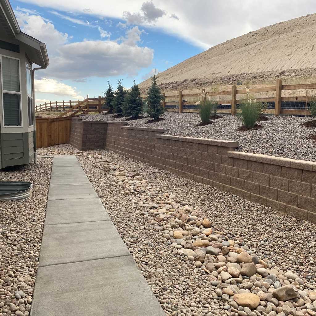 A well-constructed backyard retaining wall made of stone, enhancing the landscape's stability and aesthetics in Parker, CO.